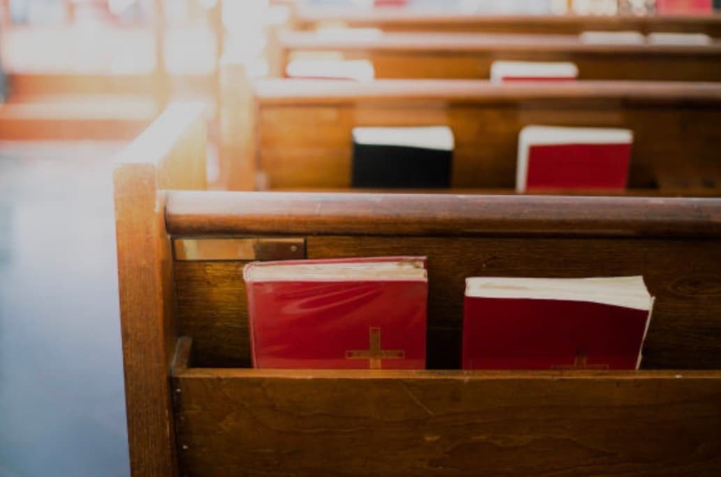 Church pews with Bibles and hymnals