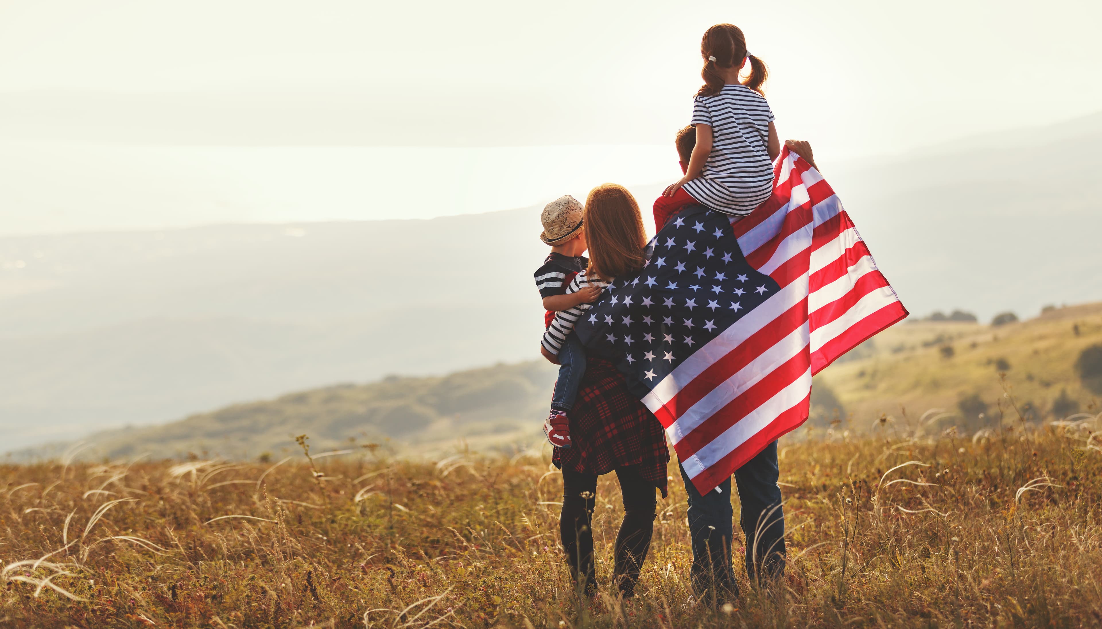 Family outdoors holding an American flag