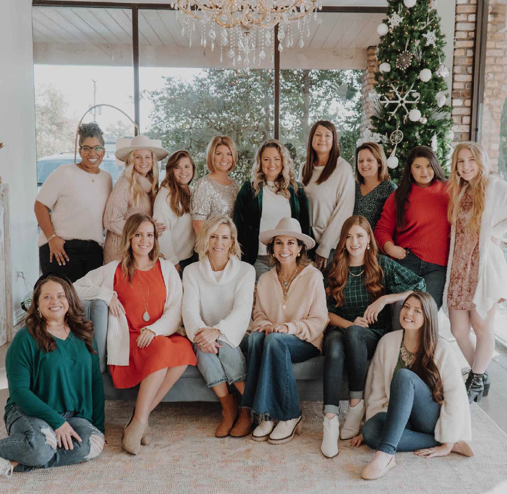Group of Women posing in front of a Christmas tree at the Embrace Grace Office