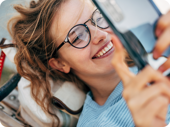 Woman smiling while using her phone